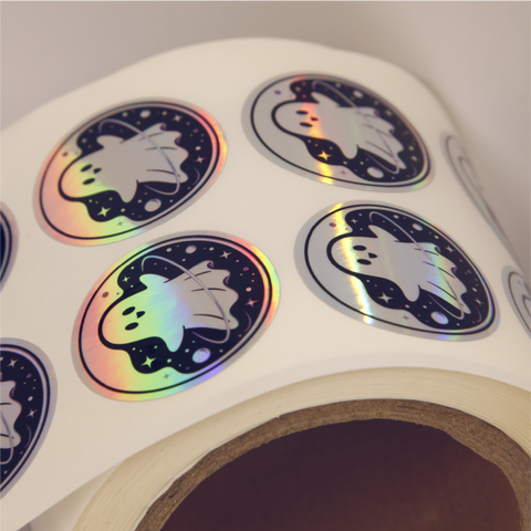 Close up shot of custom printed holographic sticker with a ghost character in space.