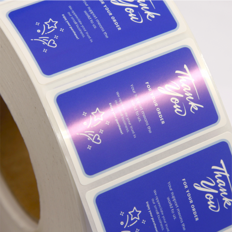 Close up of a roll of custom printed blue labels with white text 'Thank you for your order'.